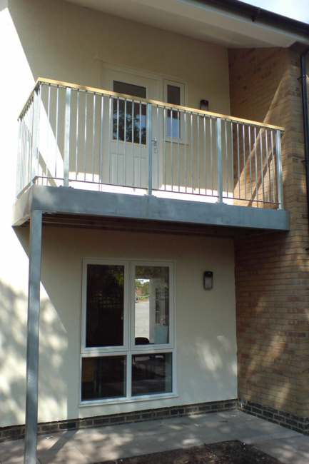 A walkout balcony with wooden handrails